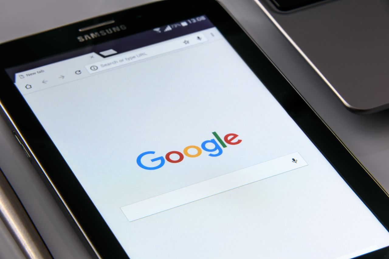 Gros plan sur une tablette affichant l’écran de recherche Google, mettant en avant la technologie et la navigation sur Internet.